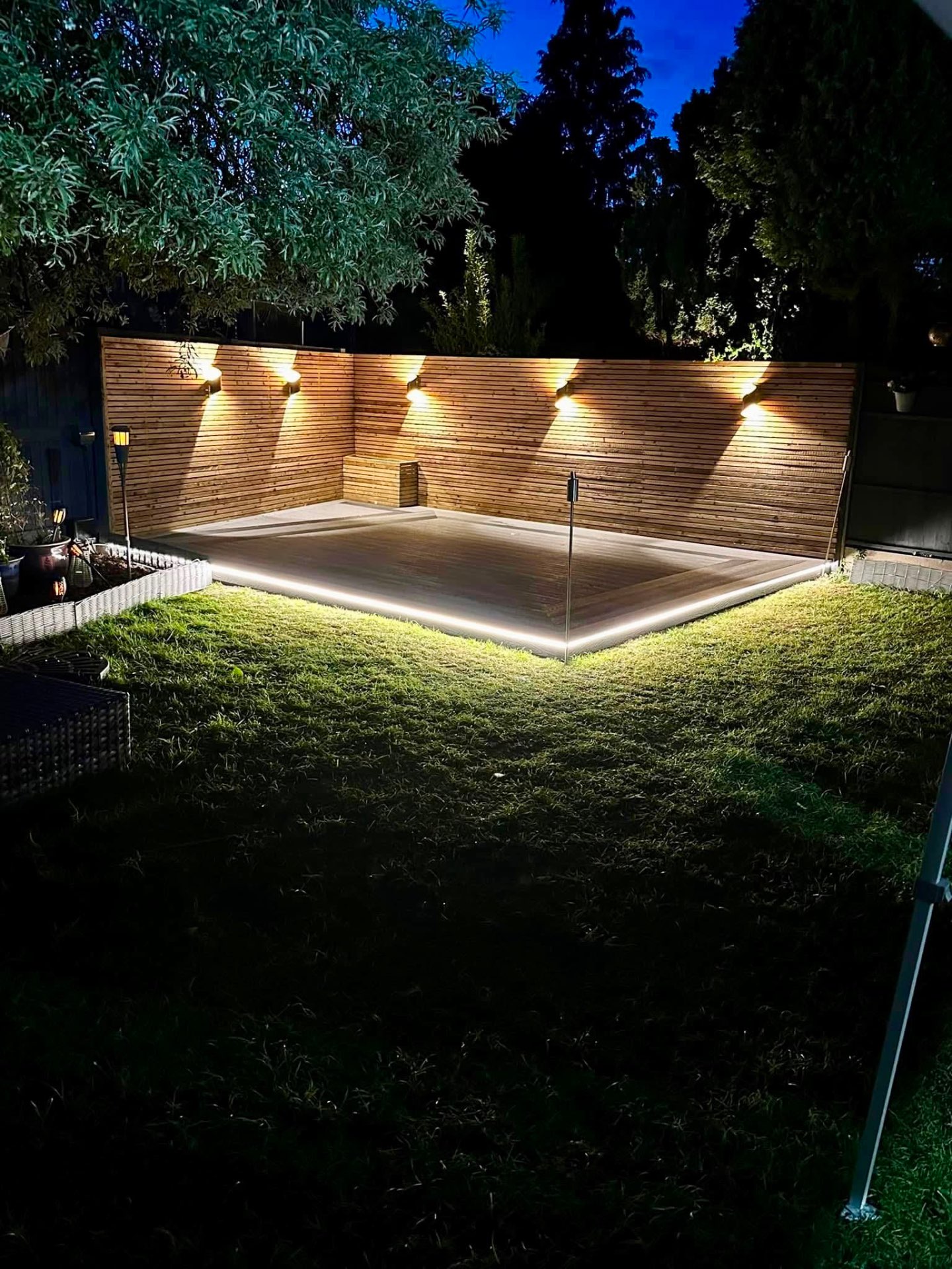 Illuminated raised deck with wall lights and LED strip underneath
