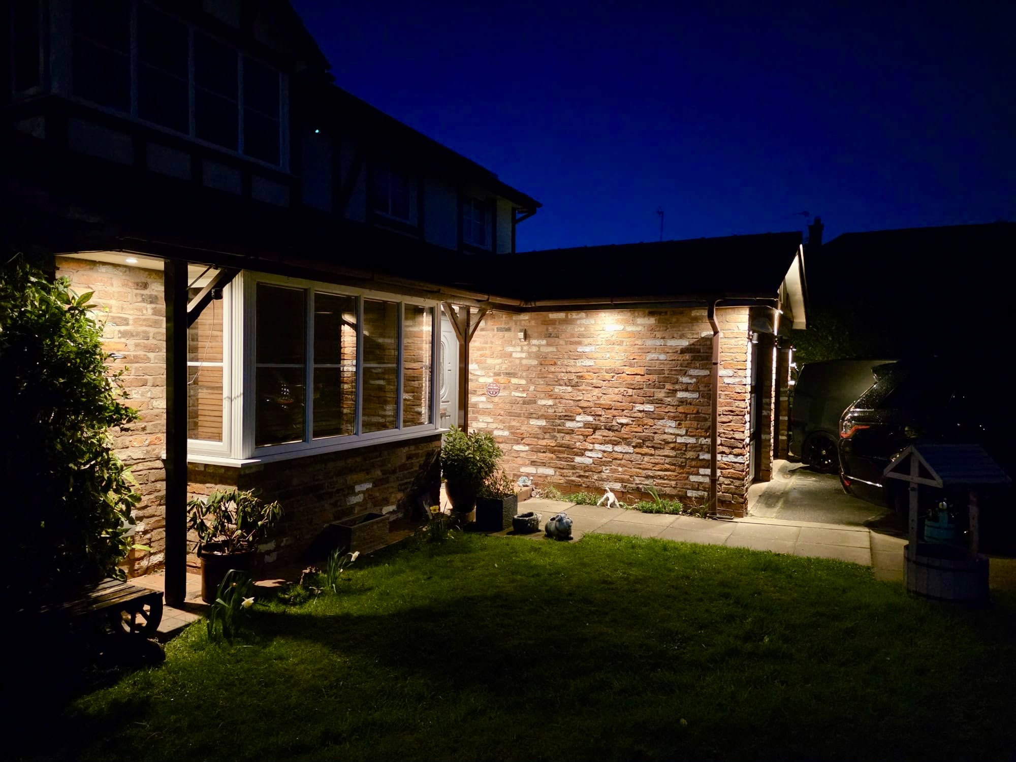 House exterior with warm downlights washing brickwork at dusk